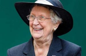 Image of a woman in a navy jacket and hat smiling, Baroness Howe