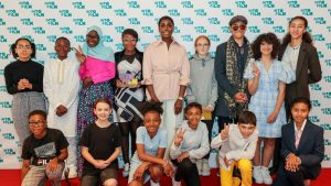 A group of children with actress Lashana Lynch